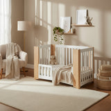 Set of four wooden cribs with white panels on a white background