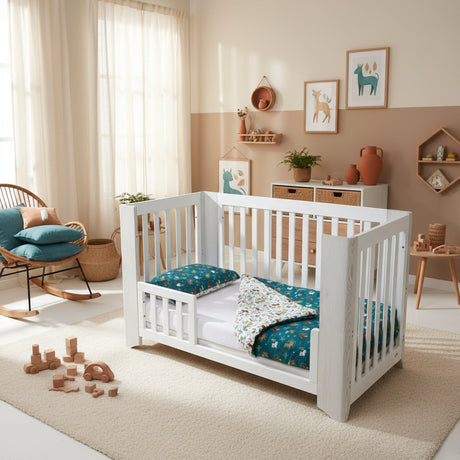 White crib with blue and white bedding featuring animal patterns on a white background