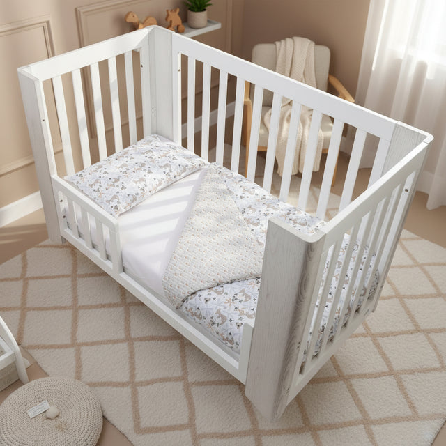 White crib with floral-patterned bedding on a white background